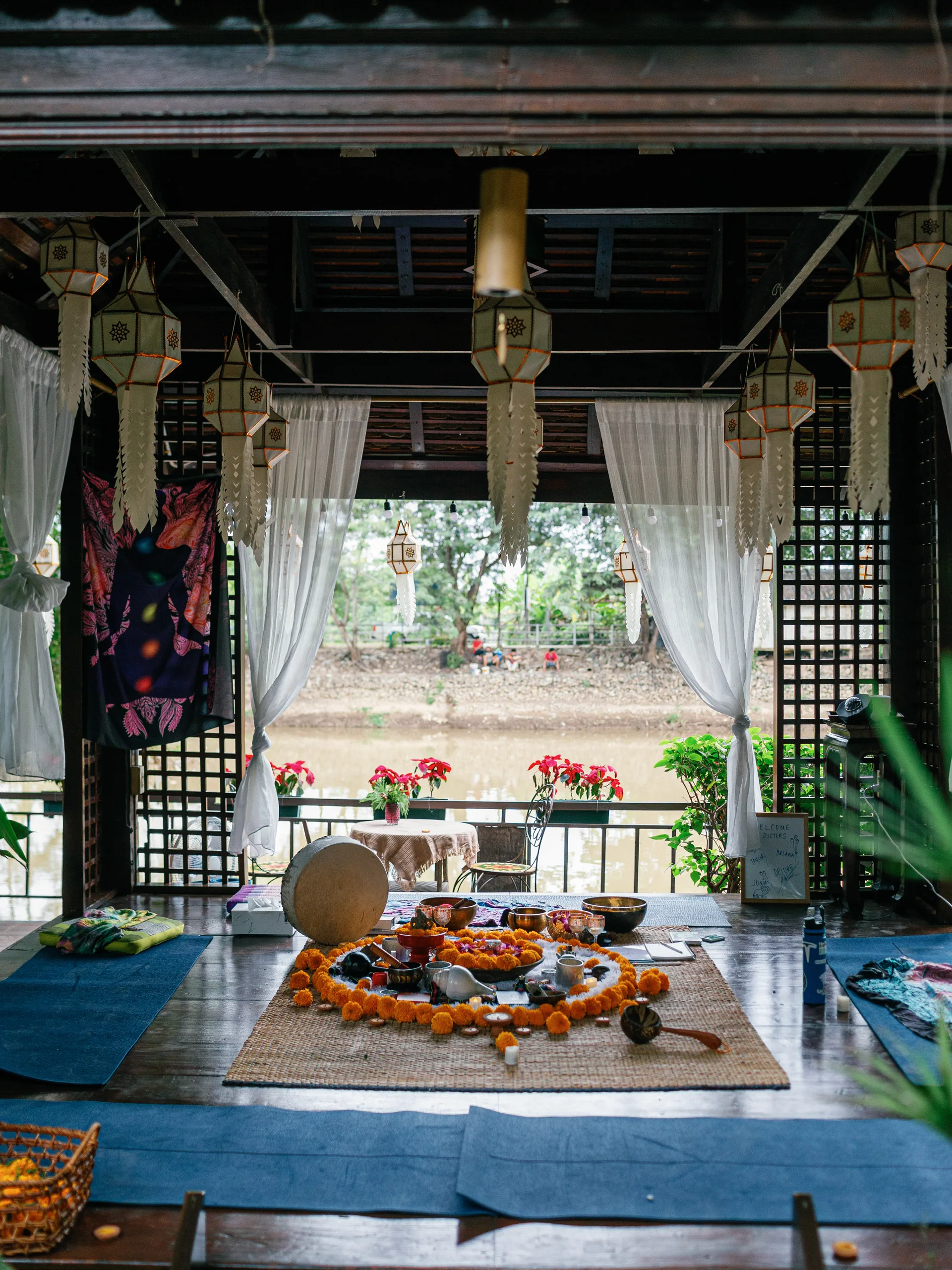 Ceremonial flowers and candlelight on a low wooden table in northern Thailand.