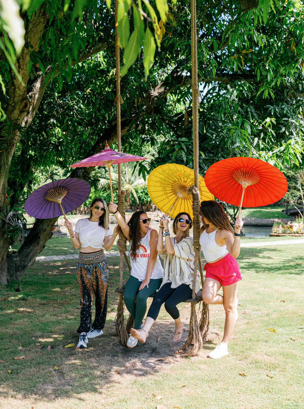 Retreat guests with colorful parasols in the Chiang Mai garden.